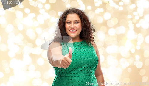 Image of happy woman showing thumbs up over lights