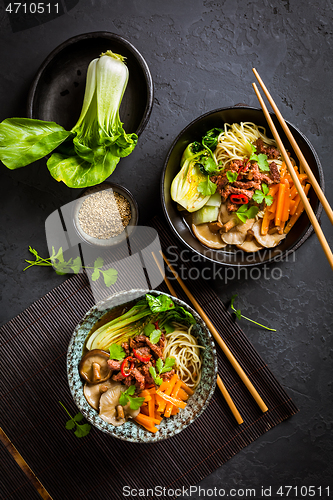 Image of Asia style ramen soup with udon noodle, beef, shiitake, pak choi cabbage and carrots