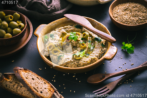 Image of Arabic Aubergine paste or dip Baba Ghanoush with olives and sesame seeds