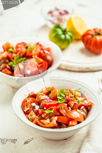 Image of Mexican Pico de Gallo with ingredients - tomato salad with onion, parsley, coriander