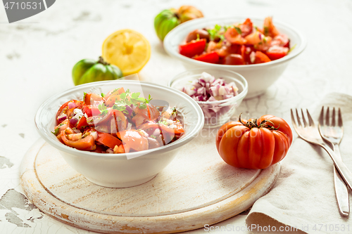 Image of Mexican Pico de Gallo with ingredients - tomato salad with onion, parsley, coriander