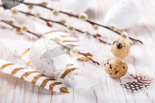 Image of Easter eggs with feathers and pussy willow branch. Easter decoration