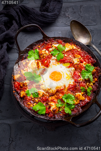 Image of Shakshuka -  dish of eggs poached in a tomato sauce with Feta cheese and coriander