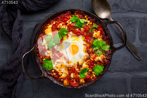 Image of Shakshuka -  dish of eggs poached in a tomato sauce with Feta cheese and coriander