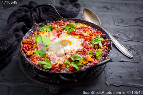 Image of Shakshuka -  dish of eggs poached in a tomato sauce with Feta cheese and coriander