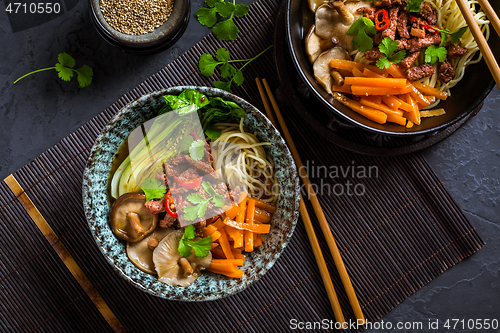 Image of Asia style ramen soup with udon noodle, beef, shiitake, pak choi cabbage and carrots