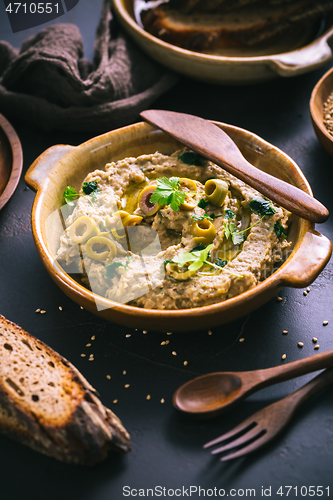 Image of Arabic Aubergine paste or dip Baba Ghanoush with olives and sesame seeds