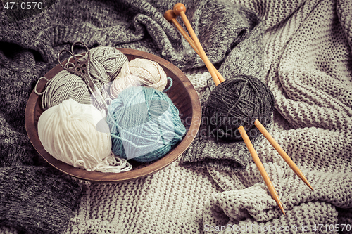 Image of Home life - Knitting concept, knitting needles with blanket, scissors and yarn in wooden bowl