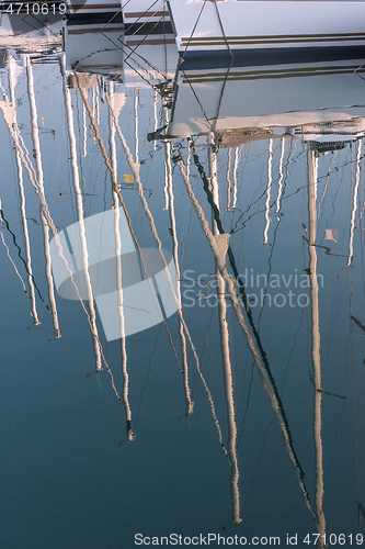 Image of Reflection of masts in the water.