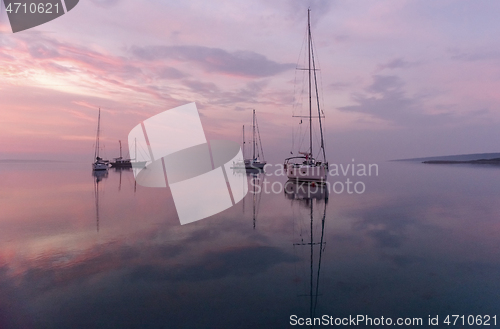 Image of Moored sailboats in the bay before sunrise