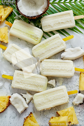 Image of Homemade vegan popsicles made with coconut milk and pineapple. Delicious healthy summer snack