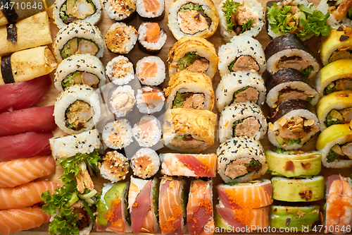 Image of Top view background with set of colorful different kinds of sushi rolls placed on wooden board