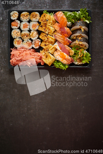 Image of Sushi take-away plastic tray with diffent kinds of rolls and copy space. Take-away food concept.