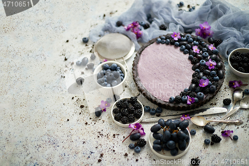 Image of Homemade blackberry tart. Sweet pie with blackberrym blueberry and grapes on stone table