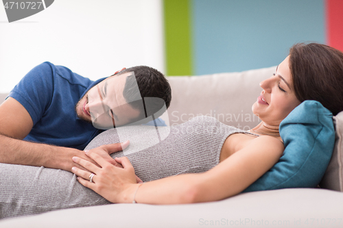 Image of future dad listening the belly of his pregnant wife