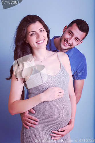 Image of pregnant couple  isolated over blue background