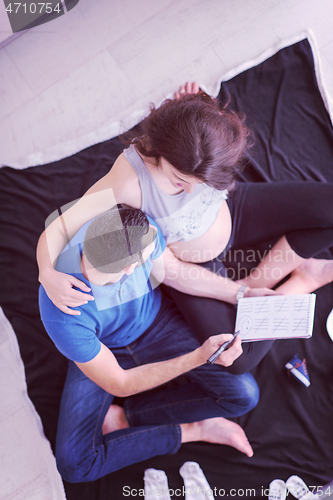 Image of top view of couple checking a list of things for their unborn ba