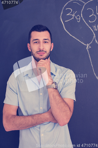 Image of portrait of man in front of black chalkboard