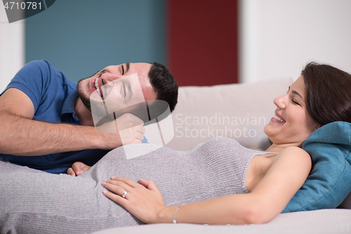 Image of future dad listening the belly of his pregnant wife