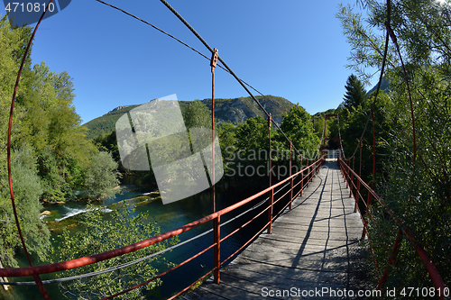 Image of wooden bridge over wild river