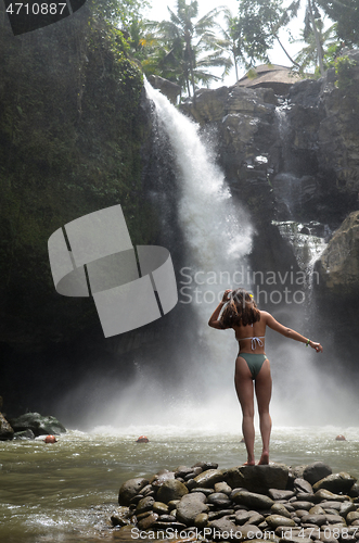 Image of Young beautiful tourist visiting the Tegenungan waterfall in Bal