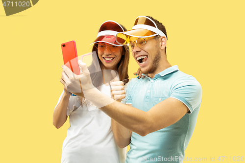 Image of Beautiful couple isolated on yellow studio background