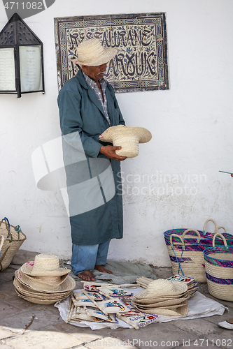 Image of Elder street vendor selling handmade souvenirs 