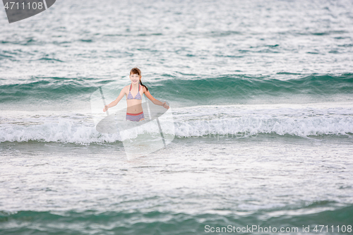 Image of Happy girl swims alone in the sea