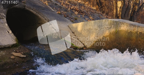 Image of Large sewage tunnel with filth flowing out