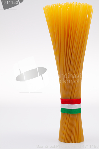 Image of Bundle of spaghetti and Italian flag on the white table