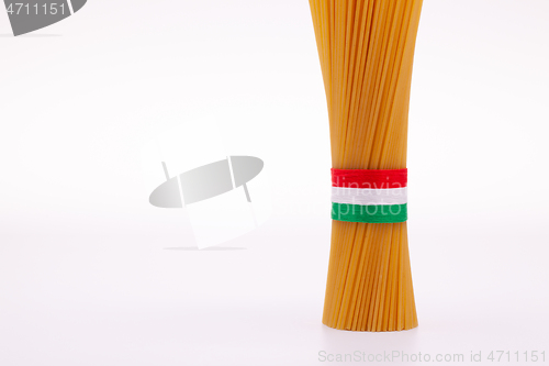 Image of Bundle of spaghetti and Italian flag on the white table