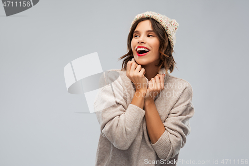 Image of young woman in knitted winter hat and sweater