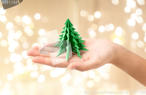 Image of hand holding green paper origami christmas tree