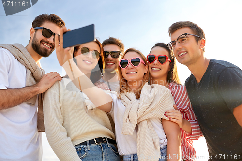 Image of happy friends taking selfie in summer