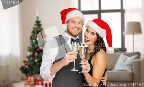 Image of couple with champagne glasses at home on christmas