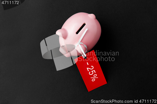 Image of piggy bank with red sale tag on black