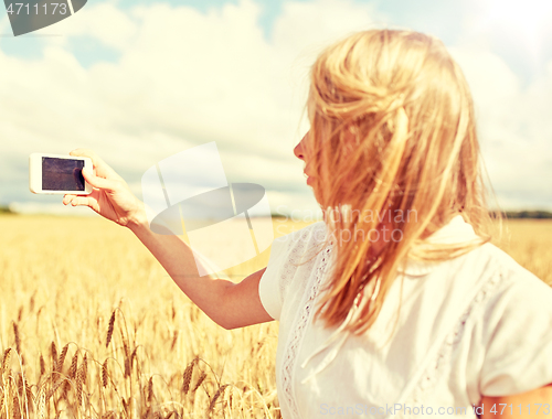 Image of close up of girl with smartphone on cereal field