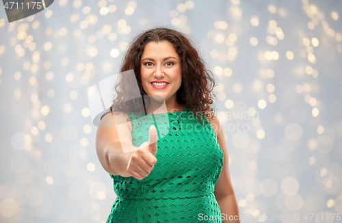 Image of happy woman showing thumbs up over lights