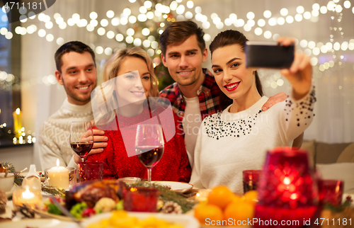 Image of friends taking selfie at christmas dinner