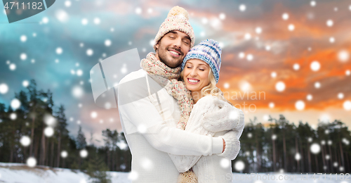 Image of smiling couple in winter clothes hugging