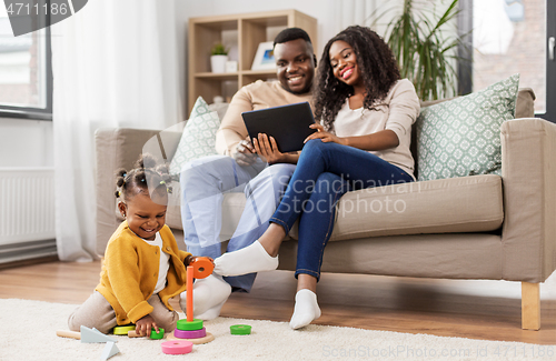 Image of african baby girl playing with toy blocks at home