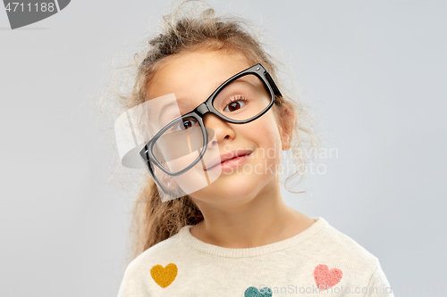 Image of smiling little girl in crookedly placed glasses