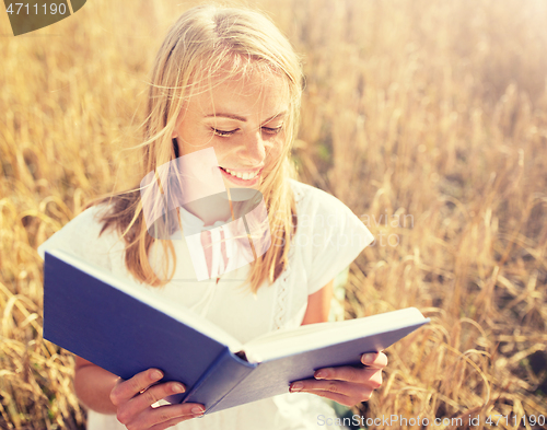 Image of smiling young woman reading book on cereal field