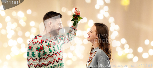 Image of happy couple with mistletoe on christmas