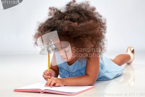Image of happy little african american girl with sketchbook
