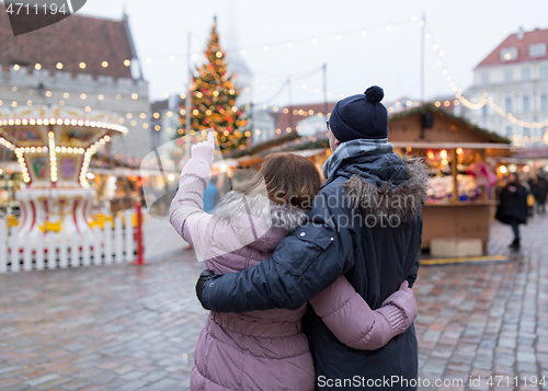 Image of happy senior couple hugging at christmas market