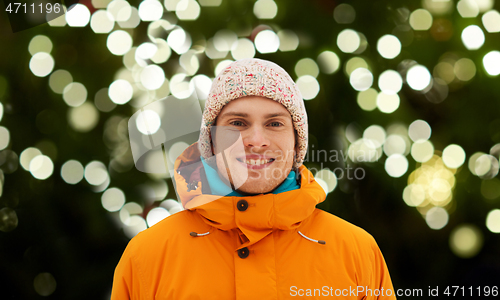 Image of happy young man in winter clothes outdoors