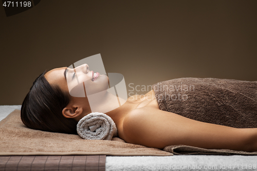 Image of young woman lying at spa or massage parlor