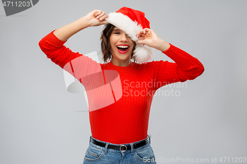 Image of happy young woman in santa hat on christmas