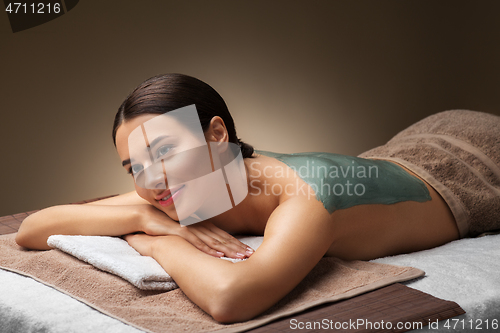 Image of woman with blue clay mask in spa